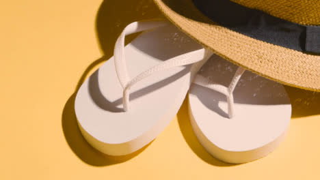 Summer-Holiday-Vacation-Concept-Of-Flip-Flops-Sandals-Sun-Hat-On-Yellow-Background
