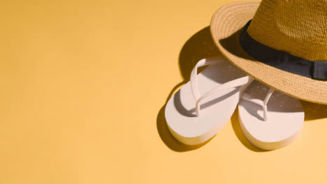 Summer-Holiday-Vacation-Concept-Of-Flip-Flops-Sandals-Sun-Hat-On-Yellow-Background-1