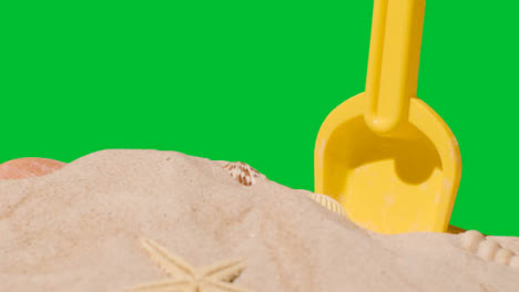 Summer-Holiday-Concept-With-Child's-Plastic-Spade-On-Sandy-Beach-Against-Green-Screen-2