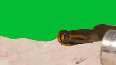 Pollution-Concept-With-Bottles-And-Rubbish-On-Beach-Against-Green-Screen-1