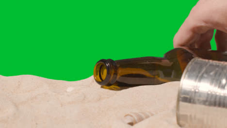 Pollution-Concept-With-Hand-Picking-Up-Bottles-And-Rubbish-On-Beach-Against-Green-Screen-1
