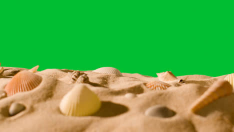 Sommerferienkonzept-Mit-Muscheln-Seestern-Am-Sandstrand-Im-Vordergrund-Gegen-Grünen-Bildschirm-2