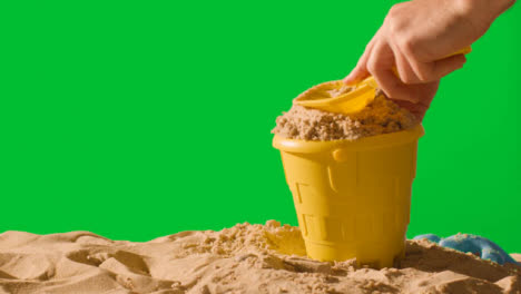 Summer-Holiday-Concept-Making-Sandcastle-On-Sandy-Beach-Against-Green-Screen-1