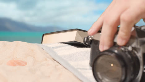 Summer-Holiday-Concept-Of-Book-Camera-Beach-Towel-On-Sand-Against-Sea-Background-2