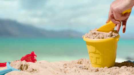 Summer-Holiday-Concept-Making-Sandcastle-On-Sandy-Beach-Against-Sea-Background-1