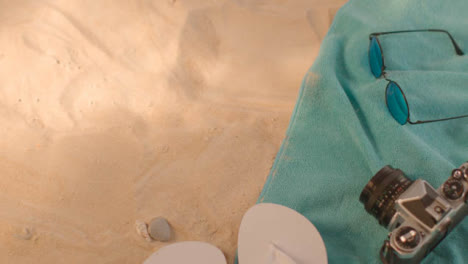Summer-Holiday-Concept-Of-Flip-Flops-Sunglasses-Beach-Towel-Camera-On-Sand-2