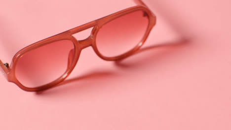 Summer-Holiday-Concept-Of-Sunglasses-On-Pink-Background