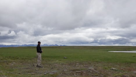 Islandia-Hombre-Parado-Bajo-Cielo-Nublado-Pan