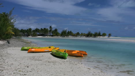 Aitutaki-Colorful-Kayaks-On-A-Beach-By-A-Lagoon-Zoom-In