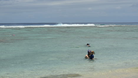 Rarotonga-Man-Helping-Boy-Learn-To-Snorkel-Editorial