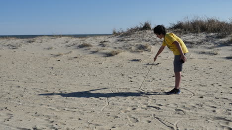 Virginia-Boy-Draws-In-Sand-With-Stick