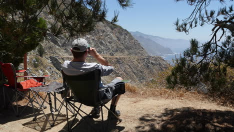 California-Big-Sur-Man-In-Chair-With-Binoculars