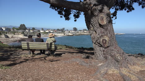 California-people-on-bench-look-over-sea-toward-Santa-Cruz