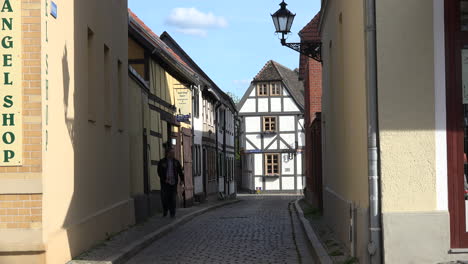 Germany-Tangermunde-man-in-alley-by-traditional-houses