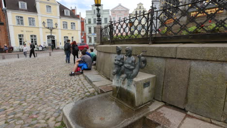 Germany-Wismar-couple-walks-away-from-fountain