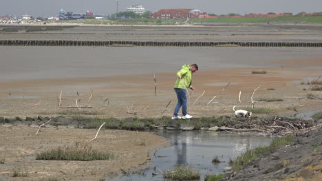 Germany-man-plus-dog-at-low-tide-at-Wadden-Sea