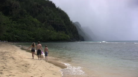 Kauai-a-family-walks-down-beach