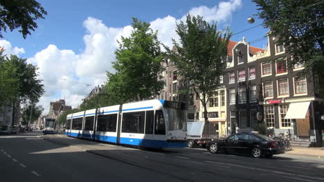 Niederlande-Amsterdam-Blaue-Straßenbahn-Passiert-Giebelgebäude