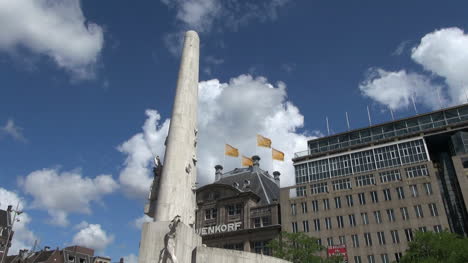 Netherlands-Amsterdam-dam-square-obelisk-and-flags-against-clouds-2