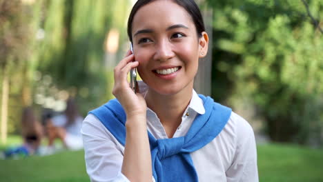 Cheerful-Woman-Talking-On-The-Phone-Outdoors