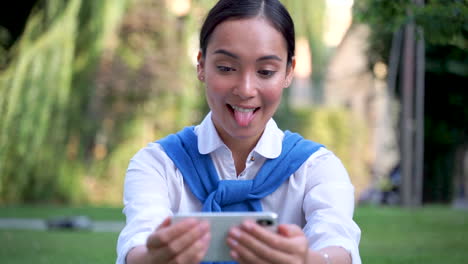 Woman-Taking-A-Selfie,-Winking-And-Sticking-Out-Her-Tongue-Outdoors