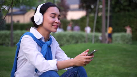 Mujer-Alegre-Escuchando-Música-Con-Auriculares-Y-Teléfono-Al-Aire-Libre