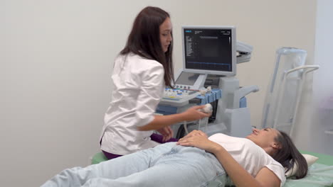 Patient-Lying-On-Hospital-Gurney,-Female-Doctor-Does-Ultrasound