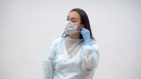Tired-Female-Doctor-Taking-Off-Surgeon-Cap-And-Face-Mask
