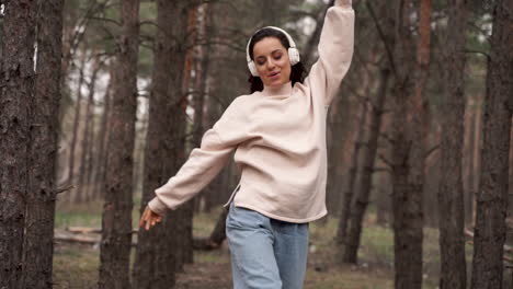 Cheerful-Beautiful-Woman-Dancing-And-Listening-Music-Alone-In-The-Forest-Enjoying-Freedom-Walking-Towards-The-Camera