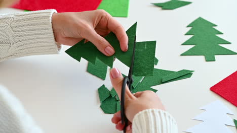 Manos-De-Mujer-Cortan-Un-árbol-De-Navidad-De-Tela-Verde-Con-Tijeras