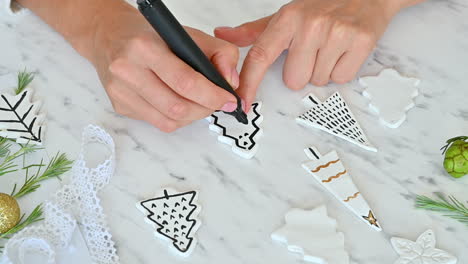 Female-Hands-Decorate-Ornaments-With-Pine-Tree-Shape-Using-A-Marker-Pen