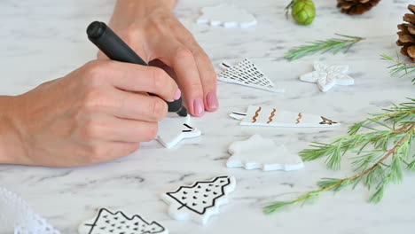 Female-Hands-Decorate-Ornaments-With-Star-Shape-Using-A-Marker-Pen