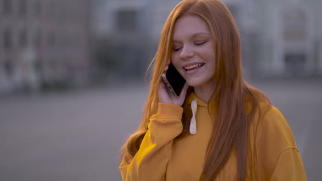 Young-Pretty-Red-Haired-Woman-Talking-On-The-Phone-Outdoors
