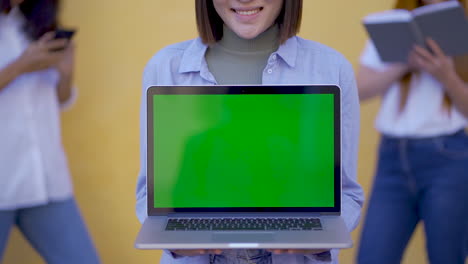 Frau,-Die-Einen-Laptop-Mit-Grünem-Bildschirm-Hält