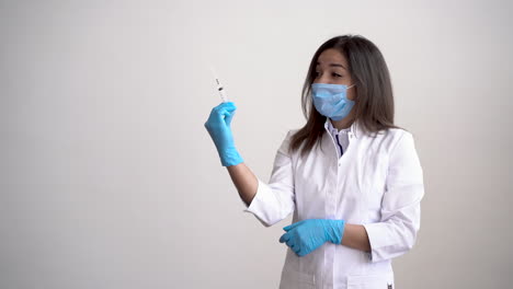 Female-Doctor-Wearing-Medical-Mask-Holding-A-Syringe-With-A-Vaccine-For-Covid-19