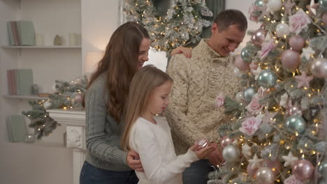 Familia-Feliz-Decora-El-árbol-De-Navidad-Con-Bolas-Y-Adornos