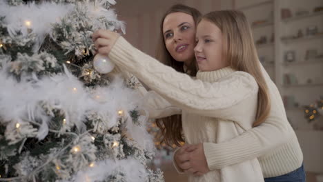 Madre-E-Hija-Decoran-El-árbol-De-Navidad-Con-Pelotas-Y-Se-Abrazan