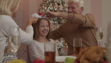 Großeltern-Setzen-Ihrer-Enkelin-Eine-Weihnachtsmütze-Auf
