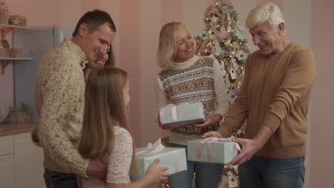 Parents,-Grandparents-And-Granddaughter-Exchanging-Christmas-Presents