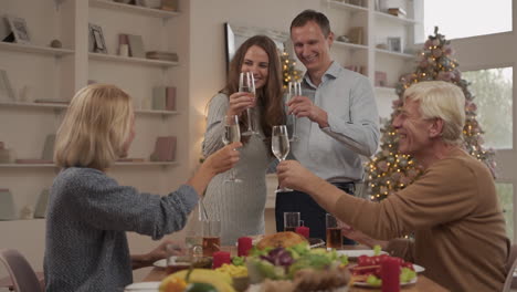 Junge-Erwachsene-Und-Ihre-älteren-Eltern-Stoßen-An-Und-Feiern-Das-Weihnachtsessen-Zu-Hause