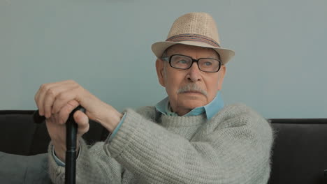 Elderly-Man-With-Gray-Mustache,-Hat,-Glasses-And-Cane