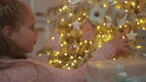 Kleines-Mädchen-Schmückt-Den-Weihnachtsbaum-Zu-Hause-Mit-Ornamenten-1