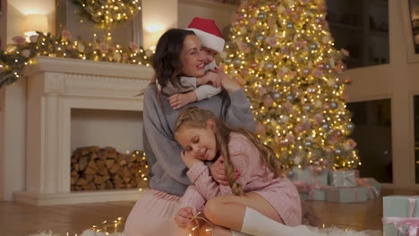 Mother,-Little-Boy-And-Girl-Hug-Next-To-The-Gifts-And-The-Christmas-Tree