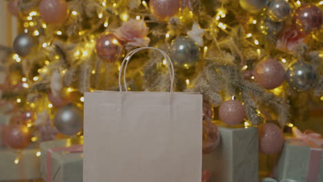 Hand-Nehmen-Sie-Eine-Weihnachtsgeschenkbox-Aus-Einer-Papiertüte-Mit-Leerzeichen