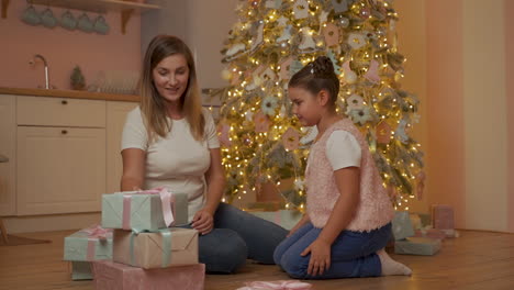 Mother-And-Little-Girl-Exchange-Christmas-Gifts-At-Home