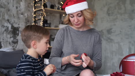 Mother-And-Son-Prepare-Ribbons-Of-Christmas-Gifts