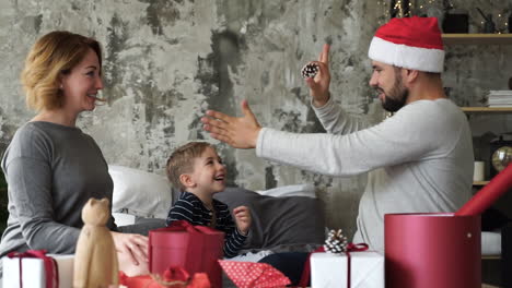 Father-Playing-With-Christmas-Decorations,-Doing-Magic-Trick,-Wearing-Red-Hat
