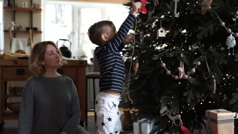 Der-Kleine-Junge-Versucht,-Den-Weihnachtsbaum-Zu-Schmücken