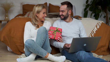 Lovely-Couple-Having-Video-Call-With-Their-Family-And-Showing-A-Christmas-Present-1