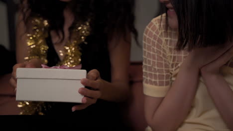 Young-Woman-Gives-A-Gift-Box-With-Bow-To-Her-Black-Female-Friend